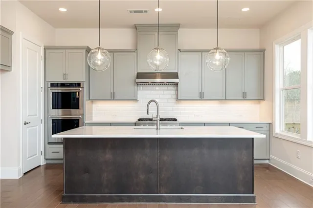 a large kitchen with stainless steel appliances granite countertop a sink a window and stainless steel appliances