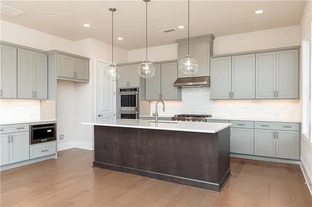 a kitchen with stainless steel appliances granite countertop a stove a sink and a refrigerator