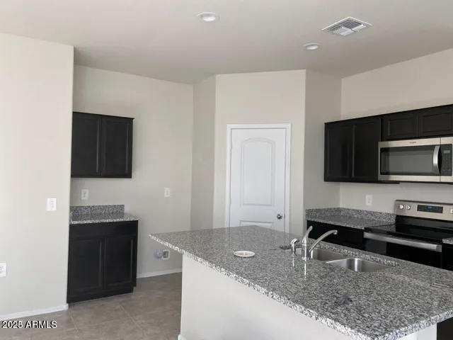 a kitchen with stainless steel appliances granite countertop a sink and a microwave