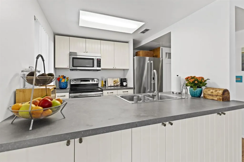 7883 Rancho Fanita Drive, Unit A Santee, CA 92071 - Photo 4 of 27 a kitchen with a sink a microwave and cabinets
