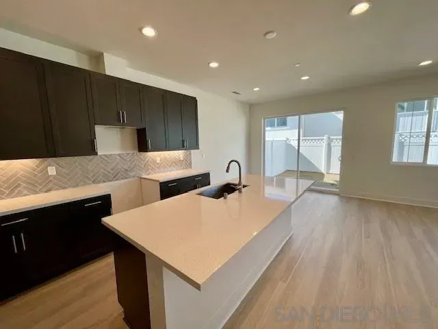 a large kitchen with kitchen island a sink dishwasher a stove and a refrigerator with wooden floor