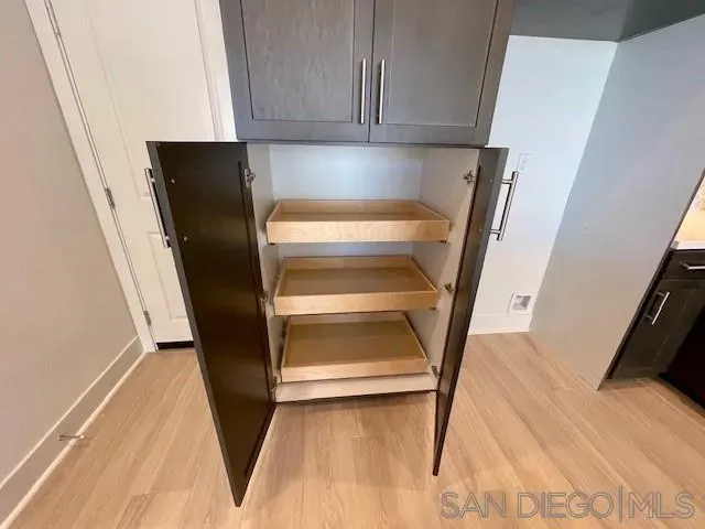 a view of entryway with wooden floor and cabinets