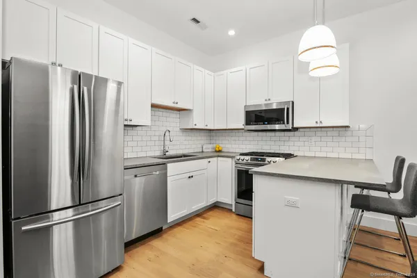 a kitchen with stainless steel appliances granite countertop a refrigerator stove microwave and sink