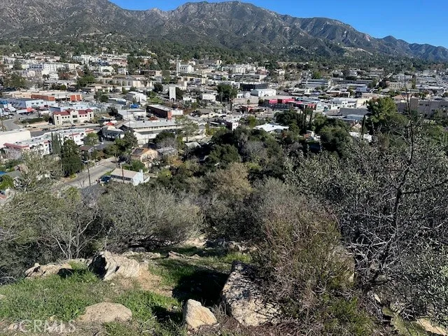 an aerial view of a houses with a lush green hillside