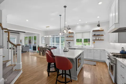 a kitchen with stainless steel appliances granite countertop a kitchen island a stove a table and chairs in it