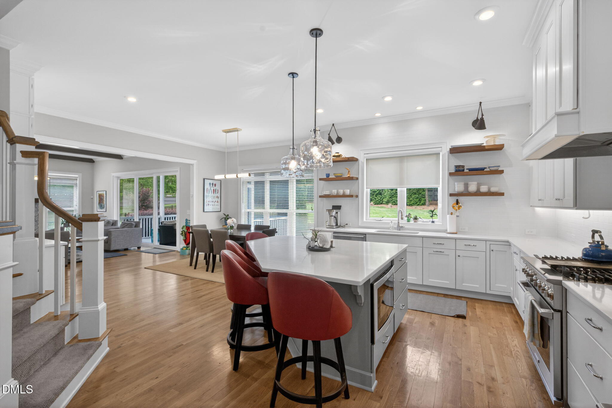 6901 Ray Family Farm Court Raleigh, NC 27613 - Photo 13 of 52 a kitchen with stainless steel appliances kitchen island granite countertop a dining table chairs stove and white cabinets