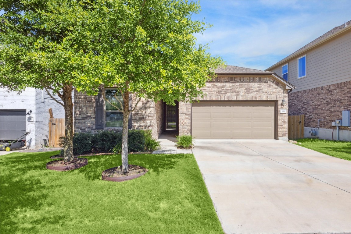 a front view of a house with a garden and trees