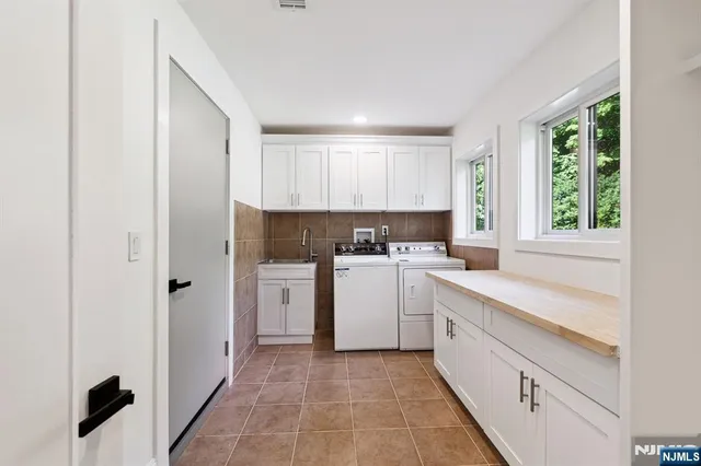 a kitchen with white cabinets and white appliances