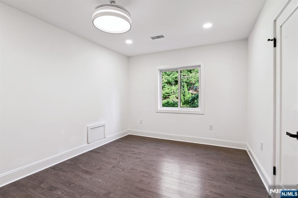 291 Tappan Road Norwood, NJ 07648 - Photo 18 of 26 an empty room with wooden floor and windows