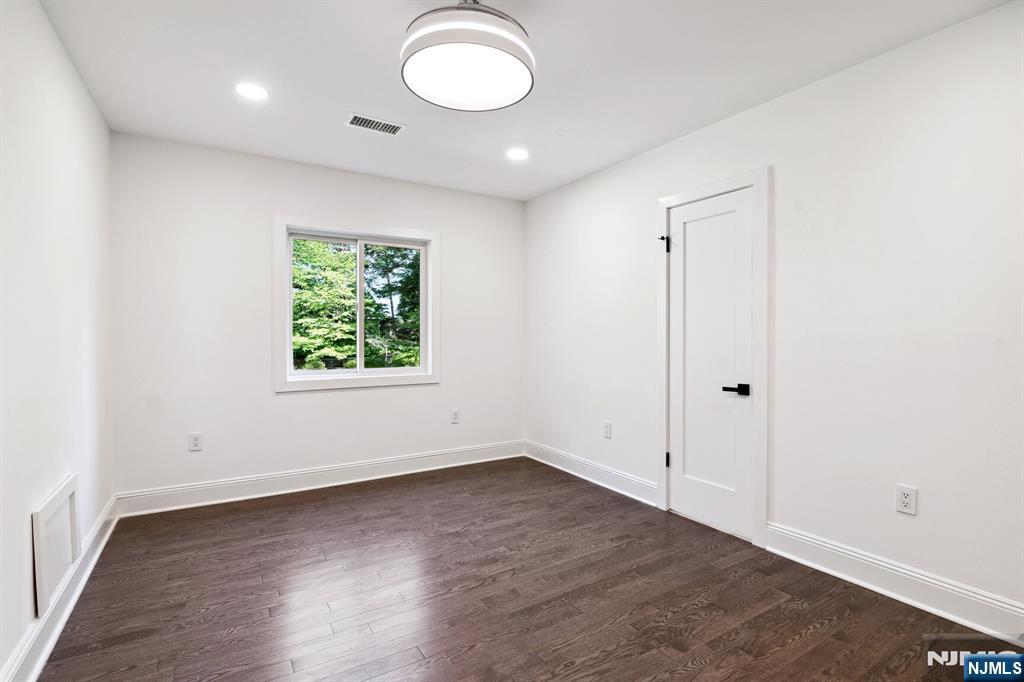 291 Tappan Road Norwood, NJ 07648 - Photo 19 of 26 an empty room with wooden floor and windows