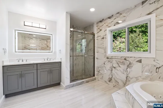 a bathroom with a bathtub sink and mirror