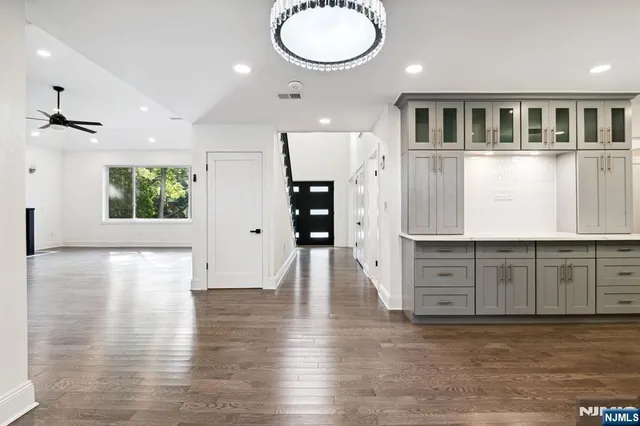 an empty room with wooden floor and cabinet