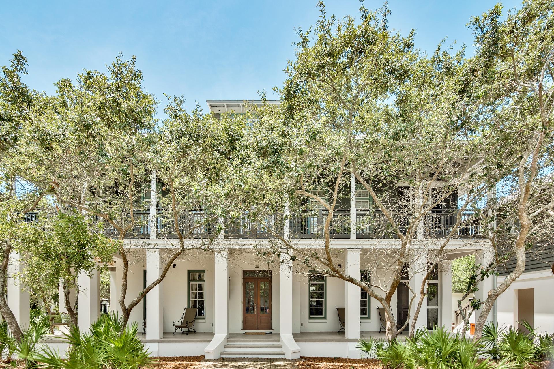 a view of a large white building with a tree in front