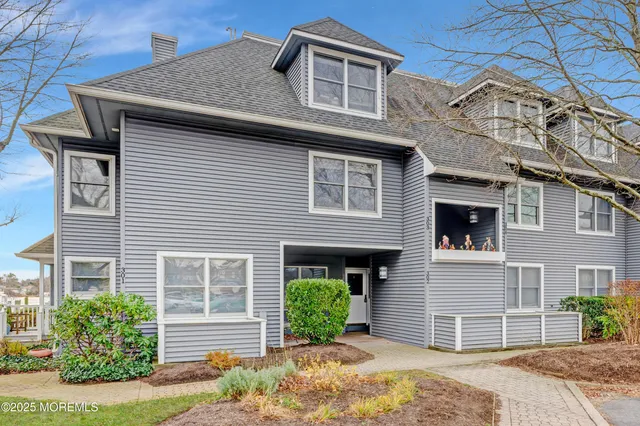 a front view of a house with a yard and potted plants