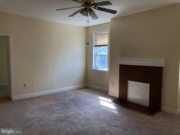 a view of an empty room with a fireplace and a window