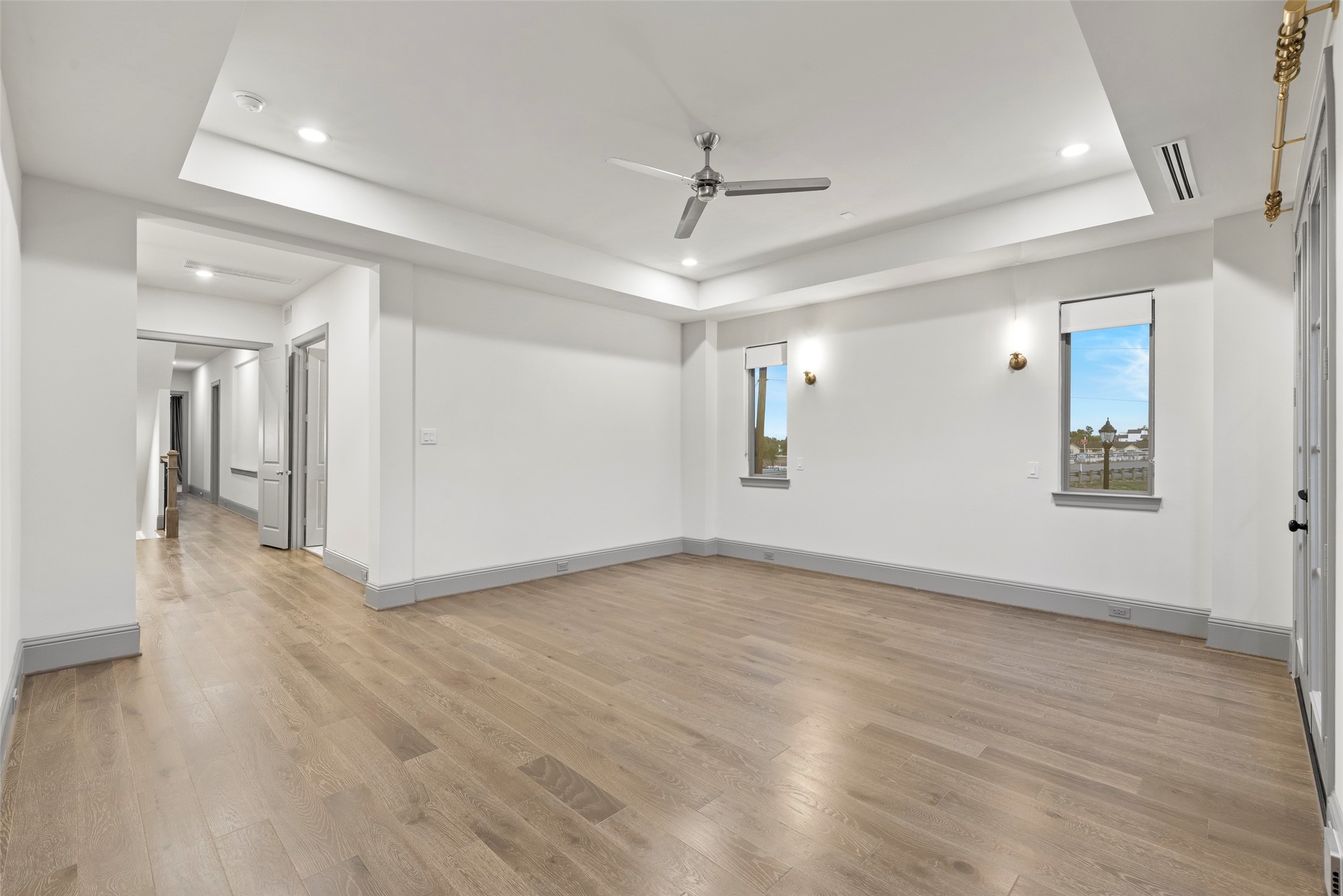 1719 Holman Street Houston, TX 77004 - Photo 18 of 40 a view of an empty room with wooden floor and a ceiling fan