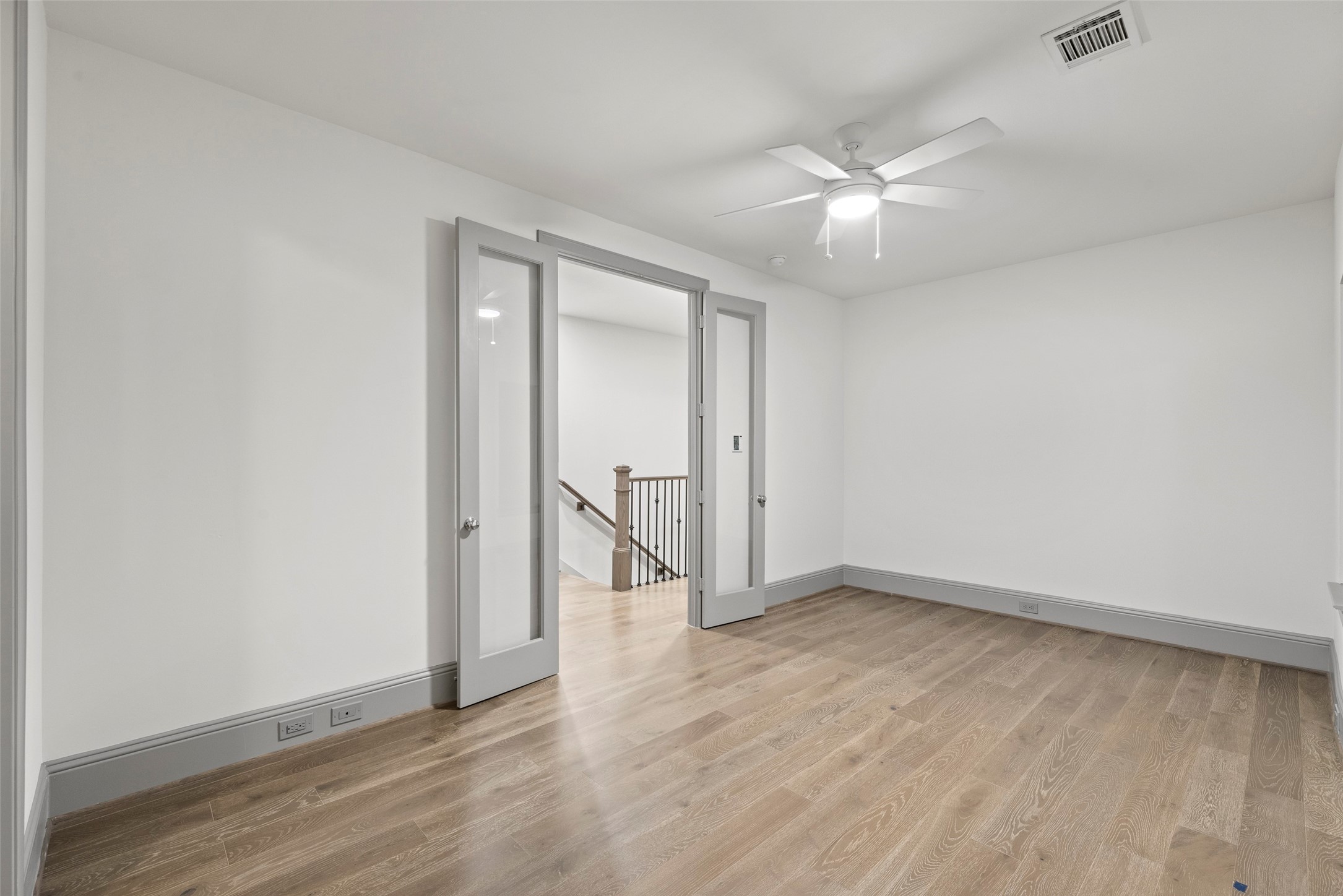 1719 Holman Street Houston, TX 77004 - Photo 37 of 40 an empty room with wooden floor and fan