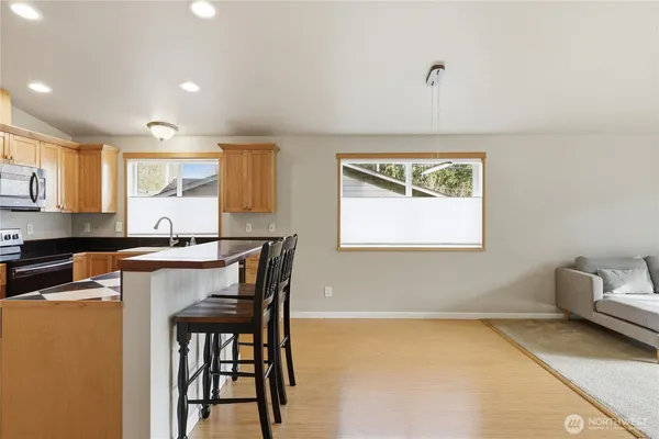 a kitchen with stainless steel appliances granite countertop a stove a sink and a microwave