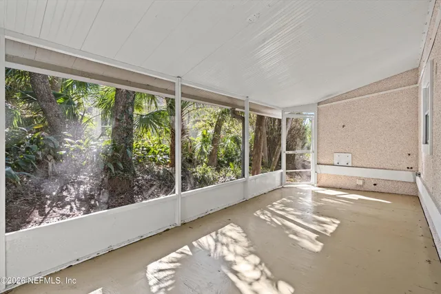 a view of a big room with wooden floor and windows