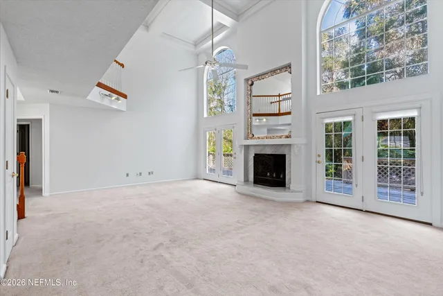 a view of an empty room with a fireplace and a window