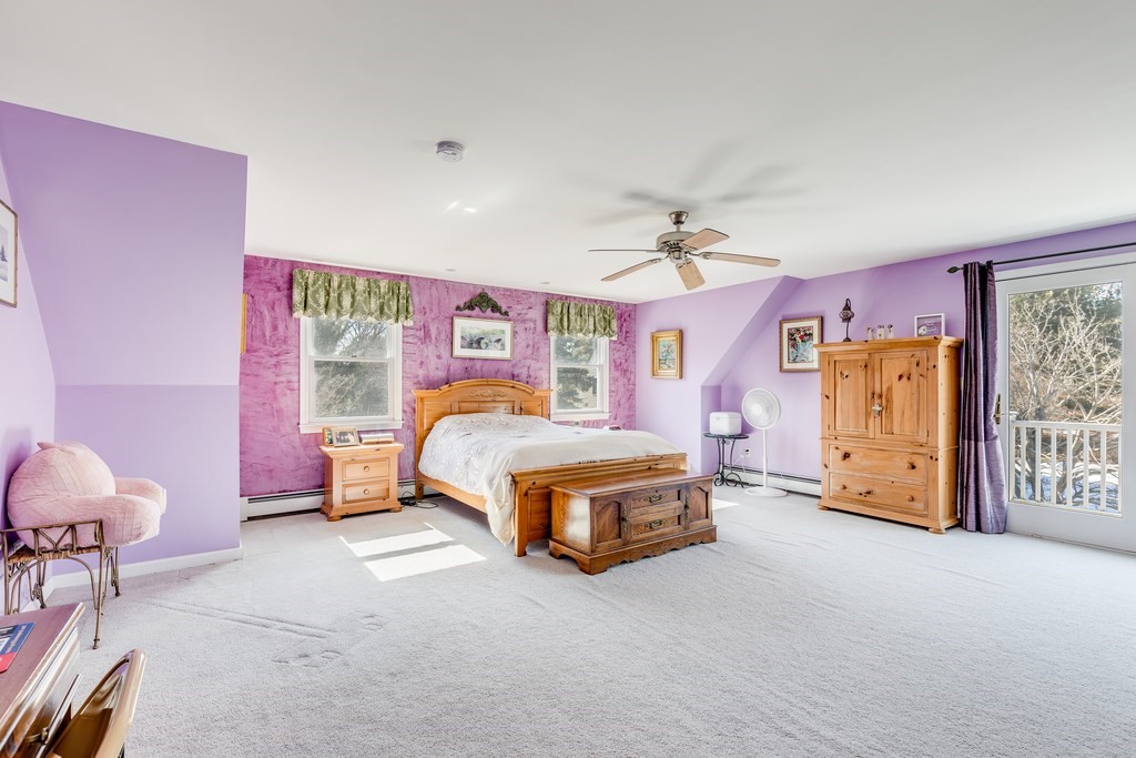 450 Main Street Rowley, MA 01969 - Photo 20 of 27 a spacious bedroom with a bed and a chandelier