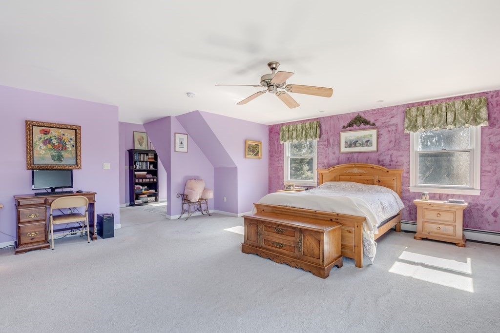 450 Main Street Rowley, MA 01969 - Photo 21 of 27 a spacious bedroom with a bed and a chandelier