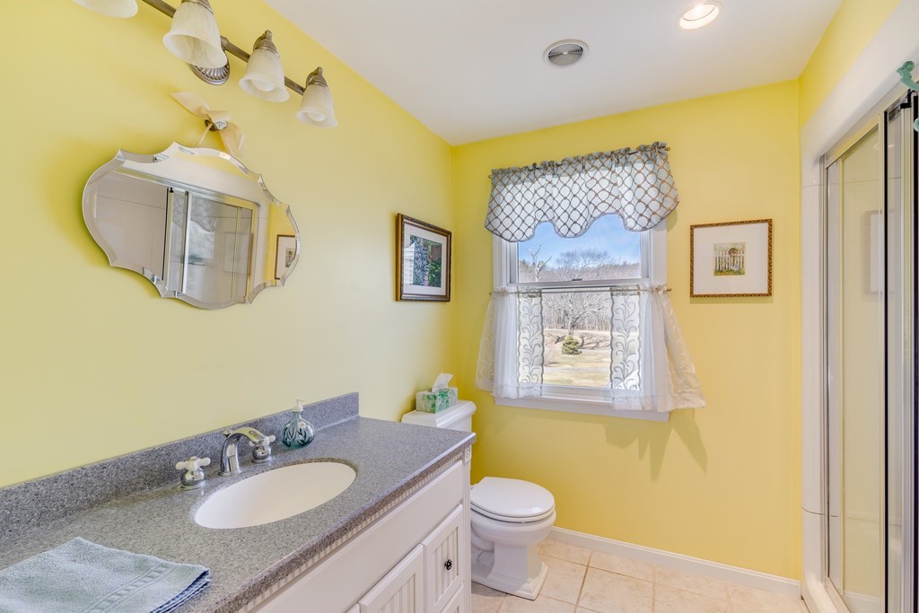 450 Main Street Rowley, MA 01969 - Photo 24 of 27 a bathroom with a granite countertop sink mirror vanity and toilet