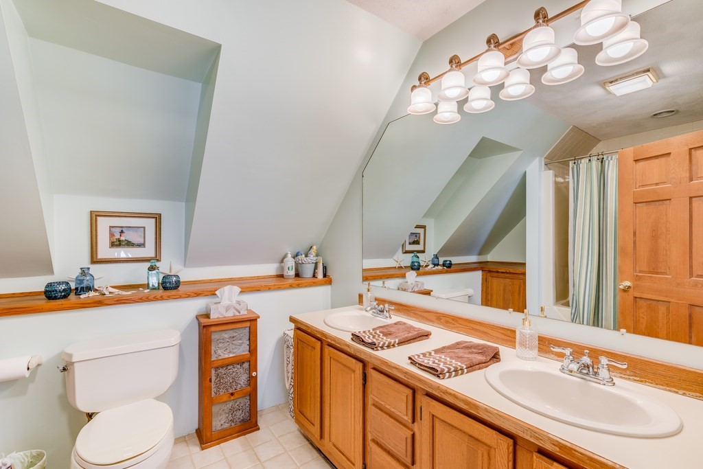 450 Main Street Rowley, MA 01969 - Photo 25 of 27 a bathroom with a granite countertop sink a toilet and a mirror