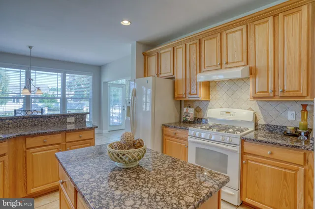 a dining room with furniture a chandelier and a large window