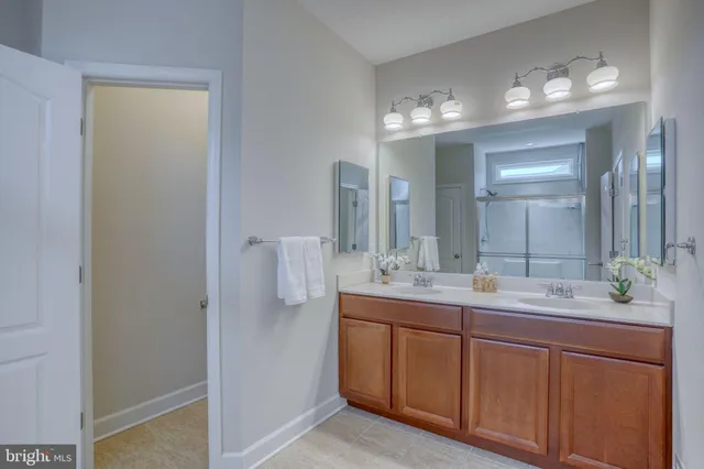 an empty room with chandelier fan and windows