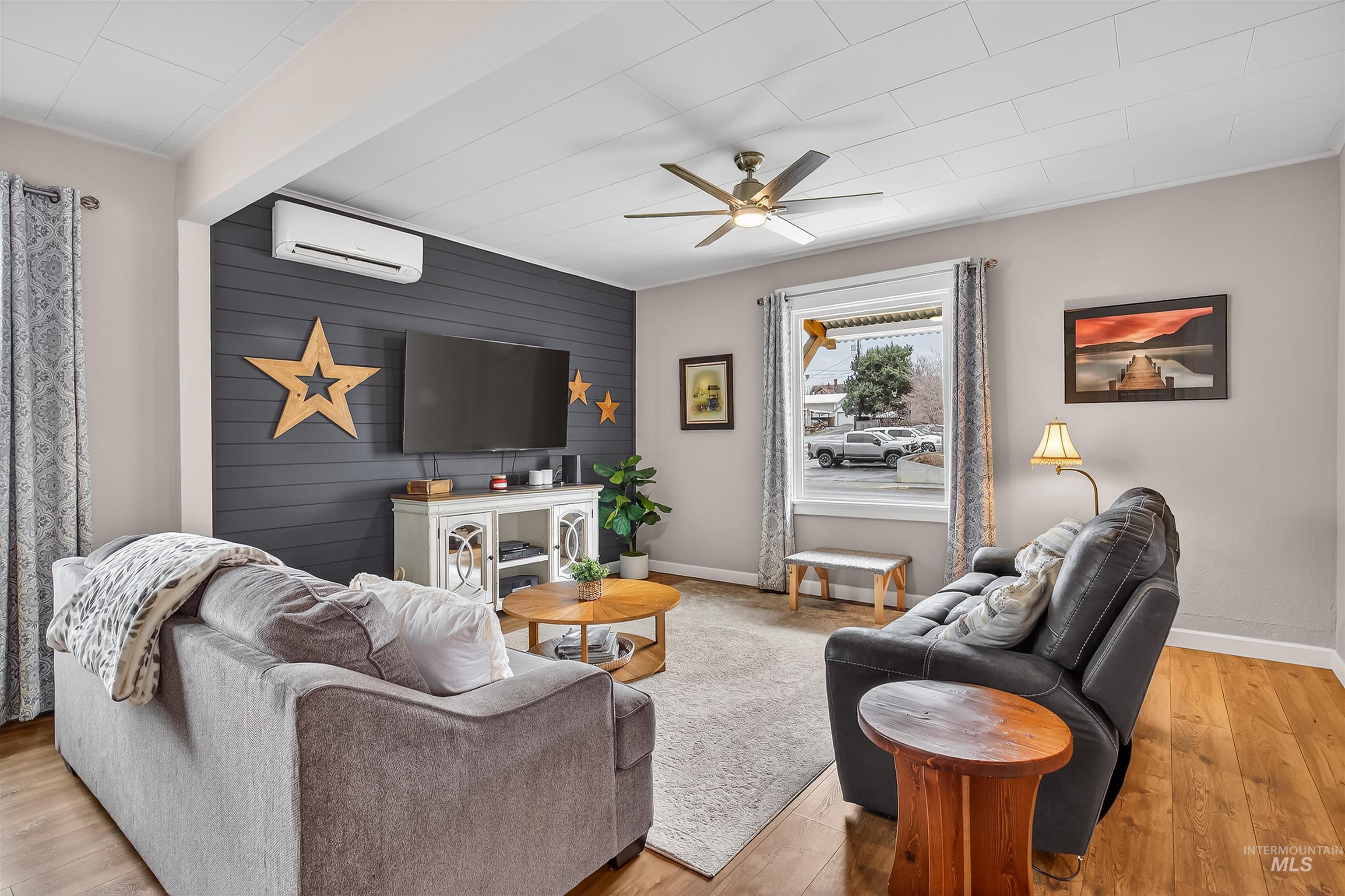 716 Chestnut Street Clarkston, WA 99403 - Photo 13 of 49 Living area with an accent wall, wood walls, light wood-style flooring, and ceiling fan