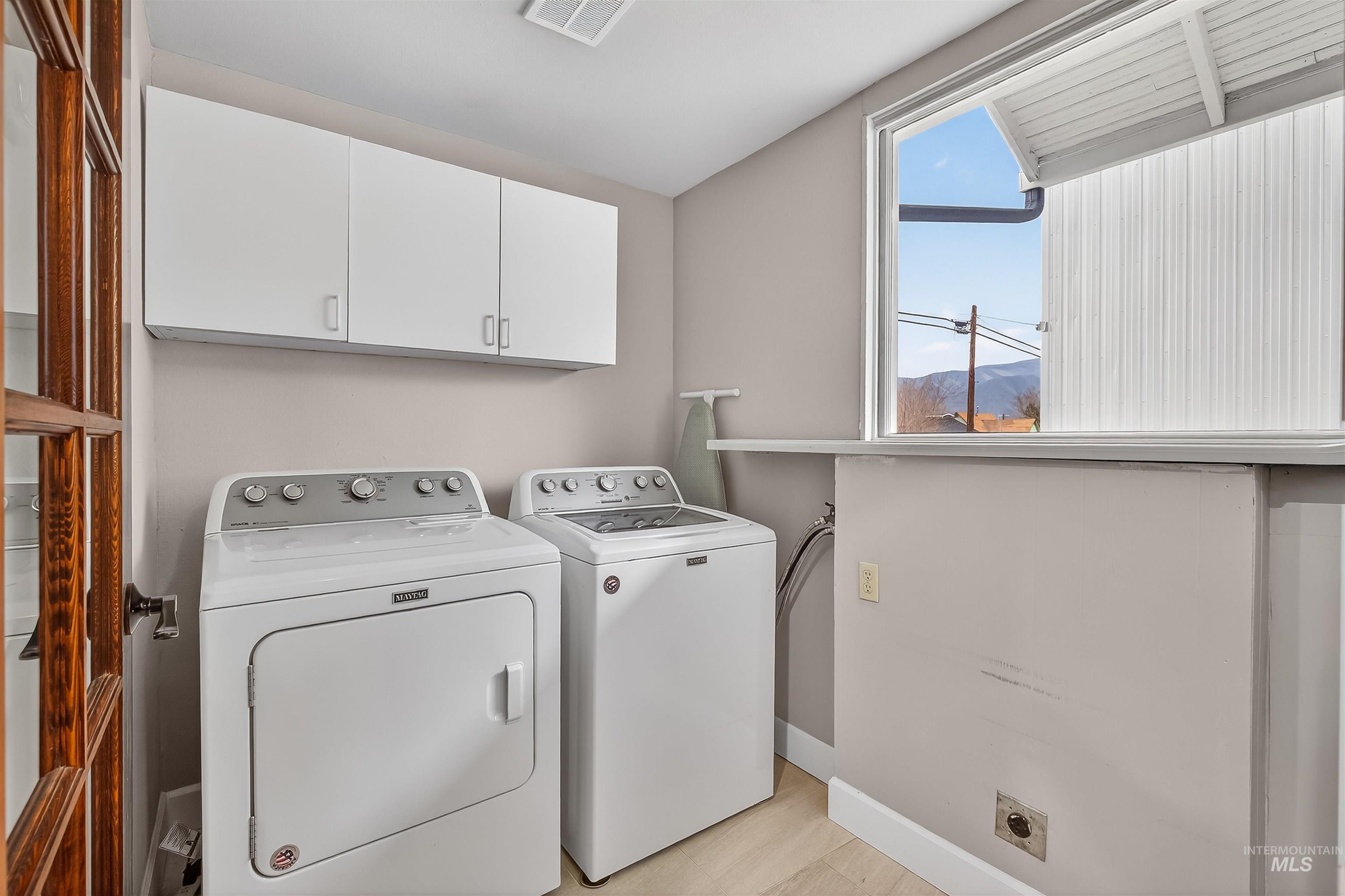 716 Chestnut Street Clarkston, WA 99403 - Photo 23 of 49 Laundry area with a mountain view, light wood-style floors, separate washer and dryer, lofted ceiling, and cabinet space