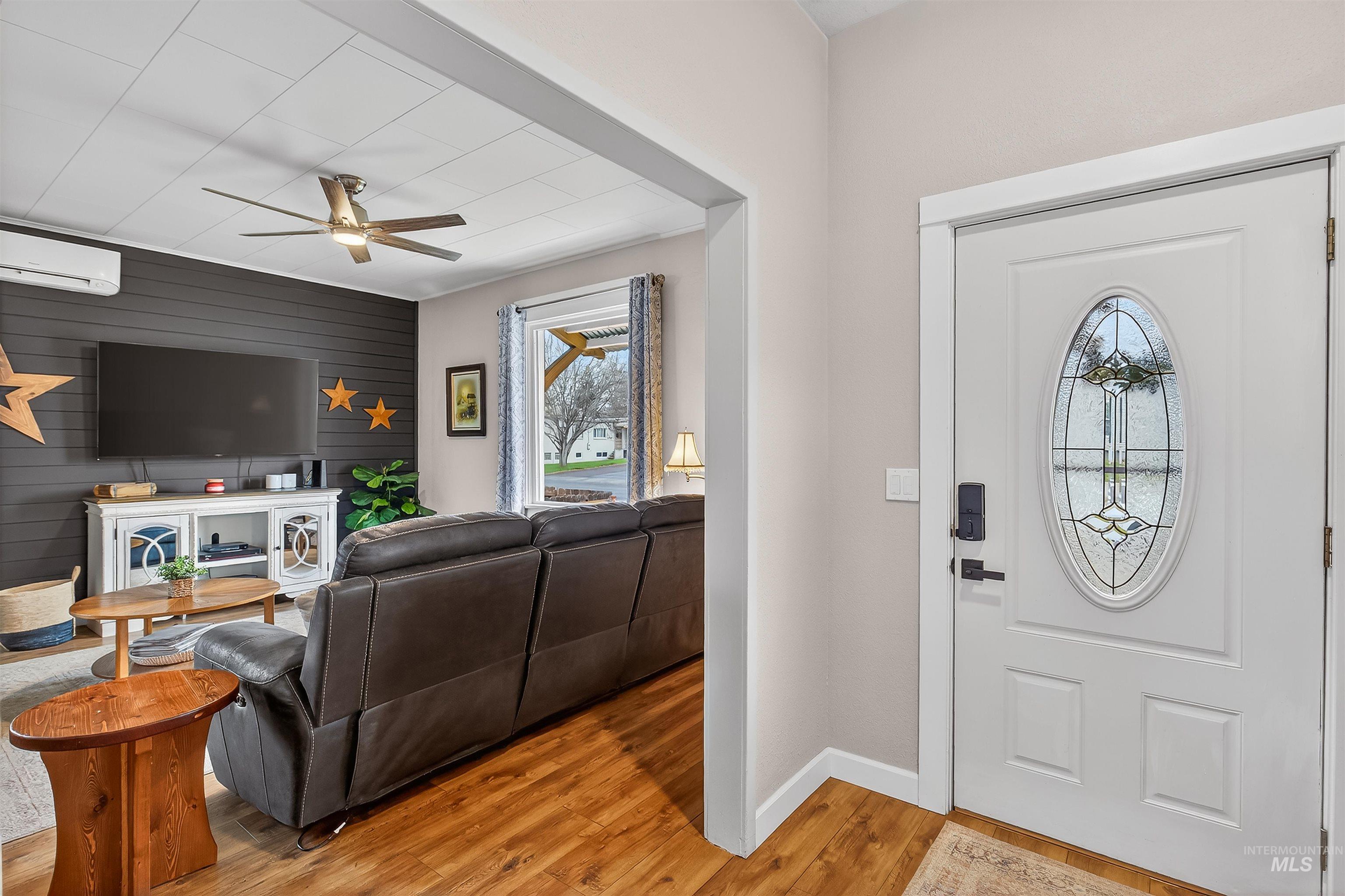 716 Chestnut Street Clarkston, WA 99403 - Photo 6 of 49 Entryway with light wood-style floors, wooden walls, a ceiling fan, and an accent wall