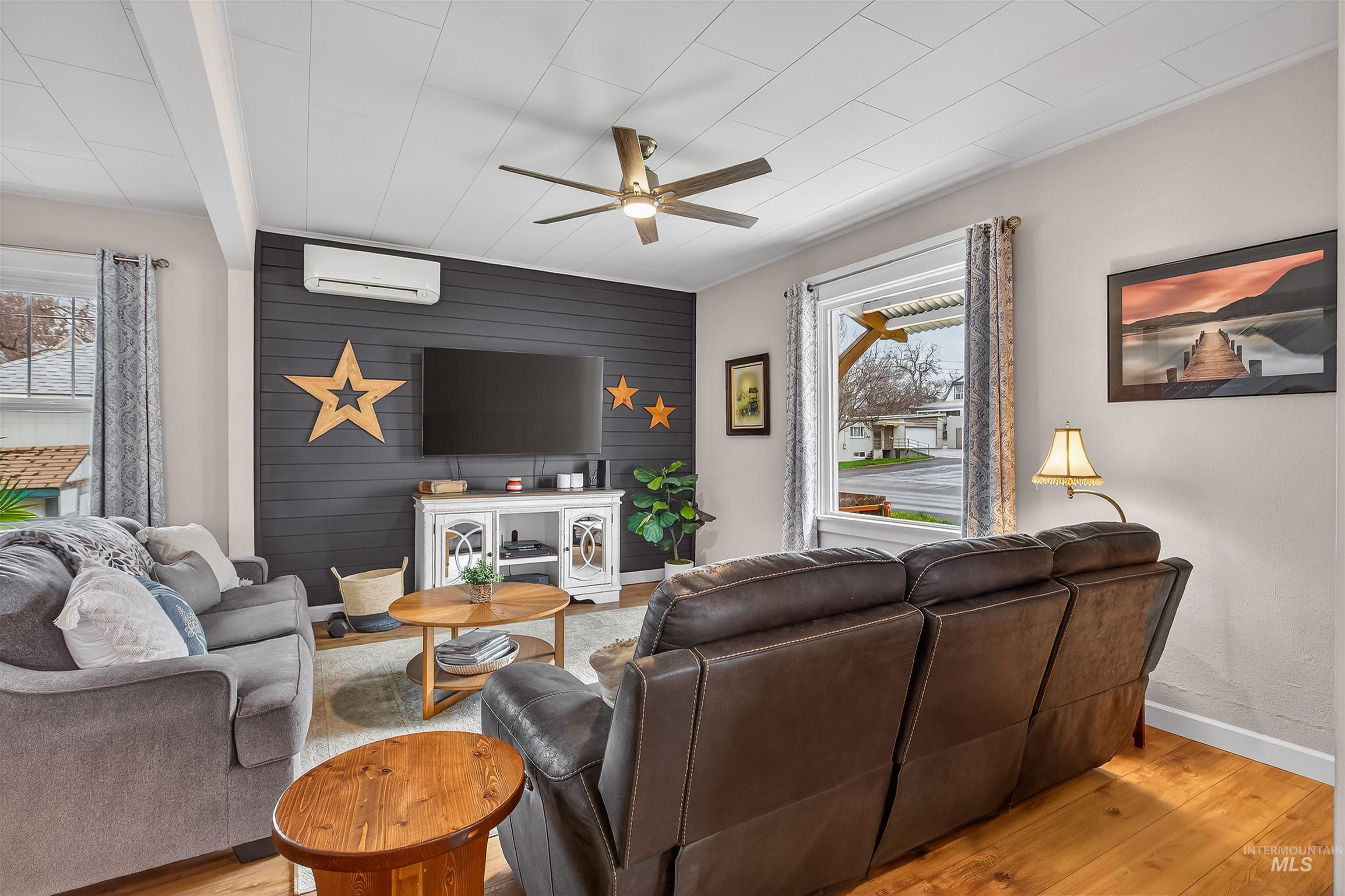 716 Chestnut Street Clarkston, WA 99403 - Photo 8 of 49 Living room with ceiling fan, light wood-type flooring, an accent wall, and wood walls