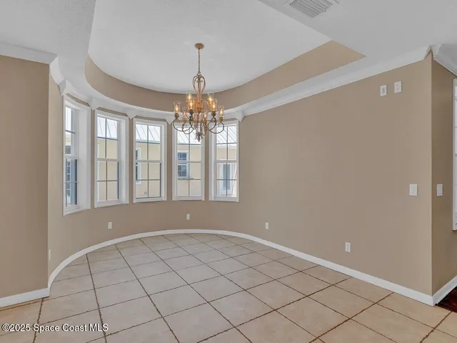 a view of an empty room with chandelier