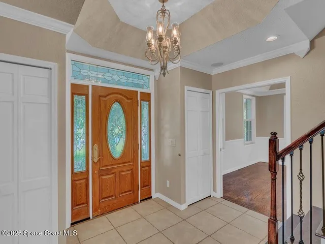 a view of a hallway with windows and chandelier