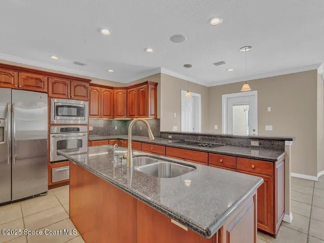 a kitchen with stainless steel appliances granite countertop a sink stove and refrigerator