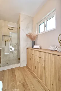 a bathroom with a granite countertop sink a mirror and shower