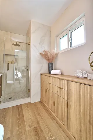a bathroom with a granite countertop sink a mirror and shower