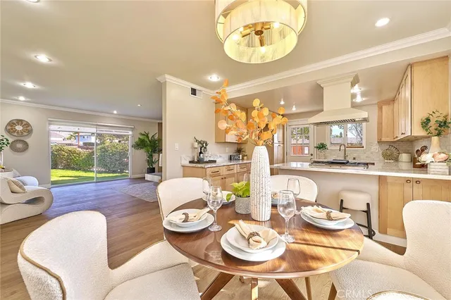 a dining room with furniture a kitchen view and wooden floor