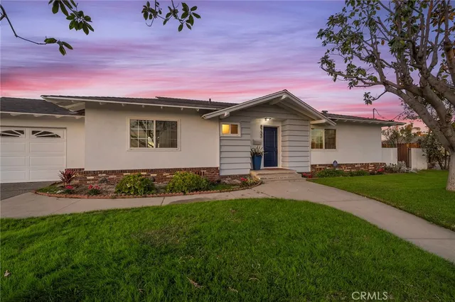 a front view of a house with a garden