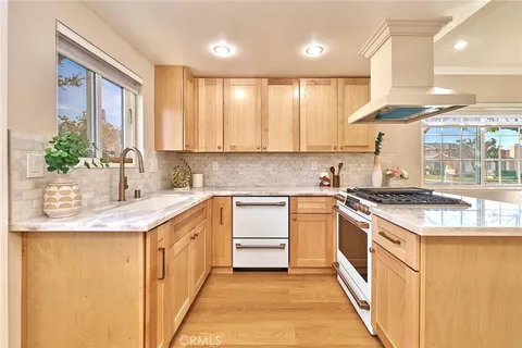 a kitchen with stainless steel appliances granite countertop a sink a stove and a refrigerator