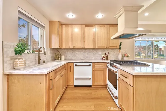a kitchen with stainless steel appliances granite countertop a sink a stove and a refrigerator