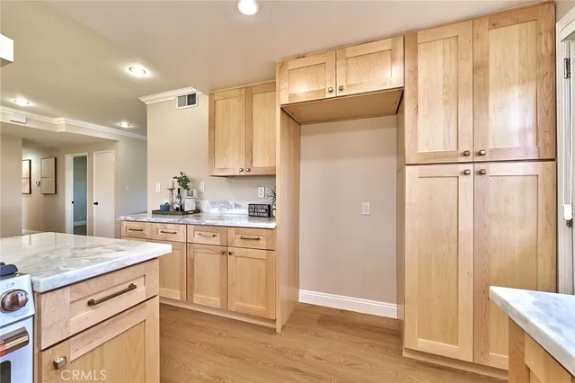 a kitchen with granite countertop white cabinets and refrigerator