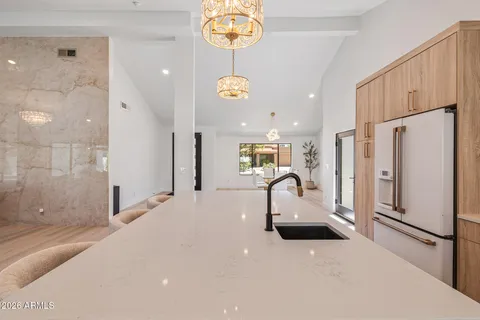 a living room with furniture a large window and wooden floor