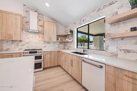a living room with a large window and a chandelier