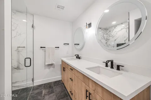 a spacious bathroom with a double vanity sink mirror and bathtub