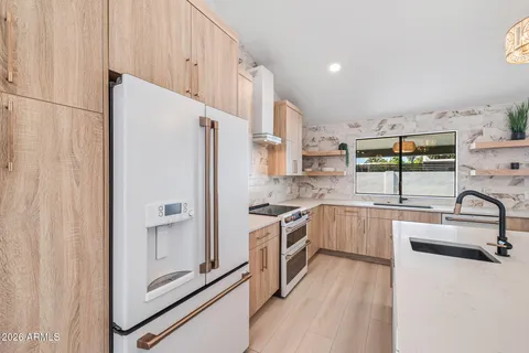 a kitchen with a stove and a wooden floor