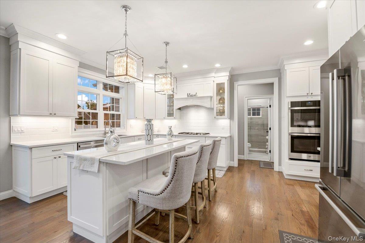 1427 Bellmore Road North Bellmore, NY 11710 - Photo 14 of 38 a kitchen with stainless steel appliances a dining table chairs sink and wooden floor