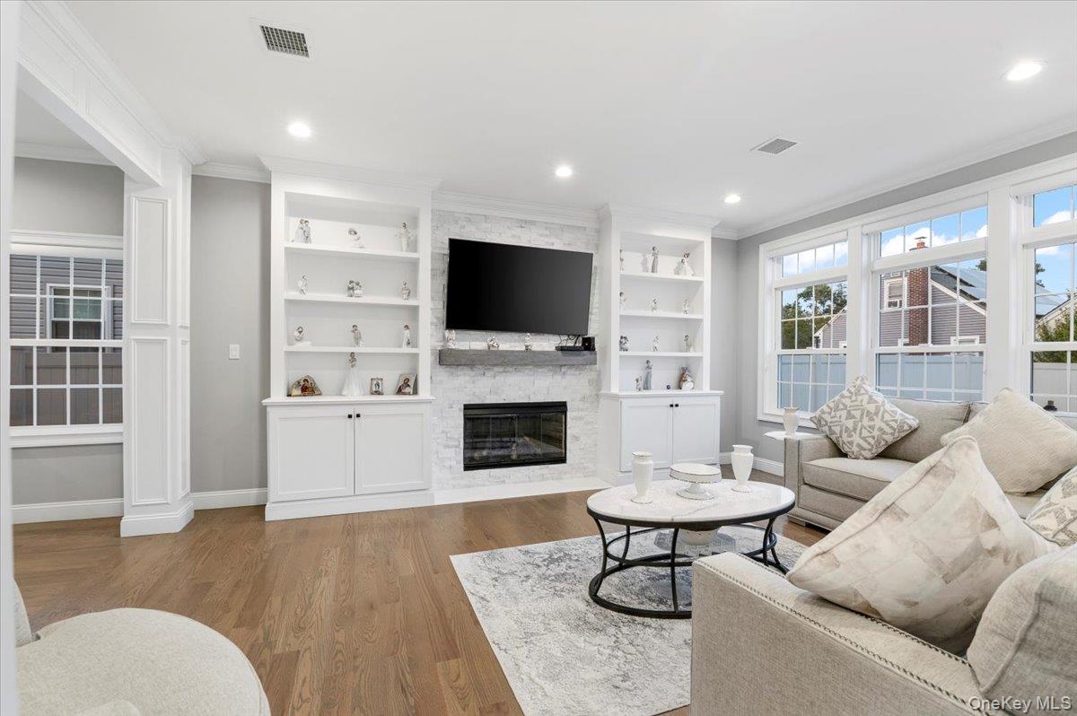 1427 Bellmore Road North Bellmore, NY 11710 - Photo 18 of 38 a living room with furniture a fireplace and a flat screen tv